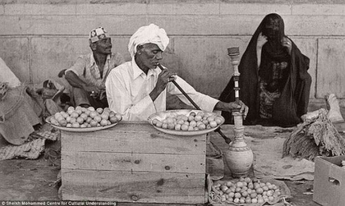Un bărbat care vinde mirodenii și lămâi, fumând o narghilea, anii 1960